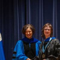 Provost Mili and woman take picture on stage